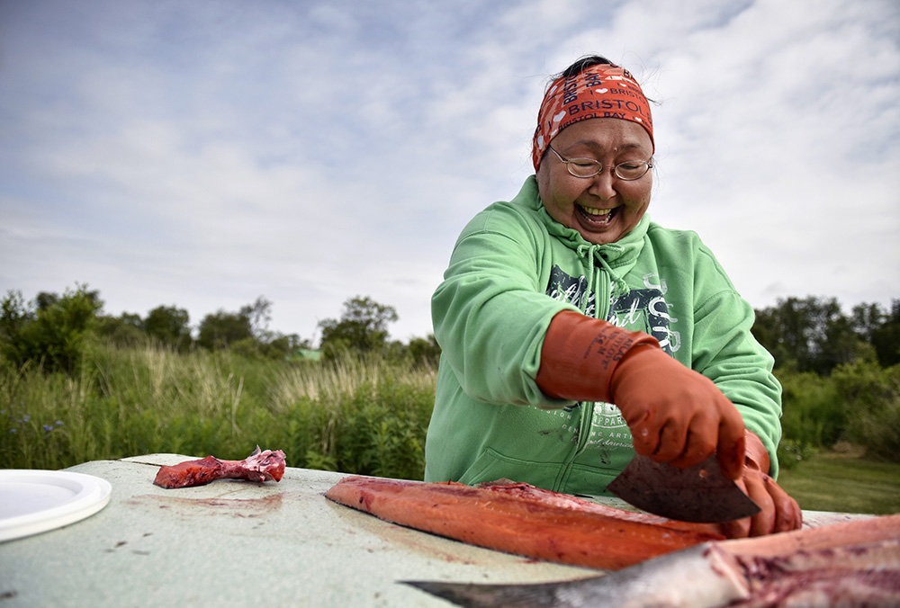 alaskan woman filleting salmon